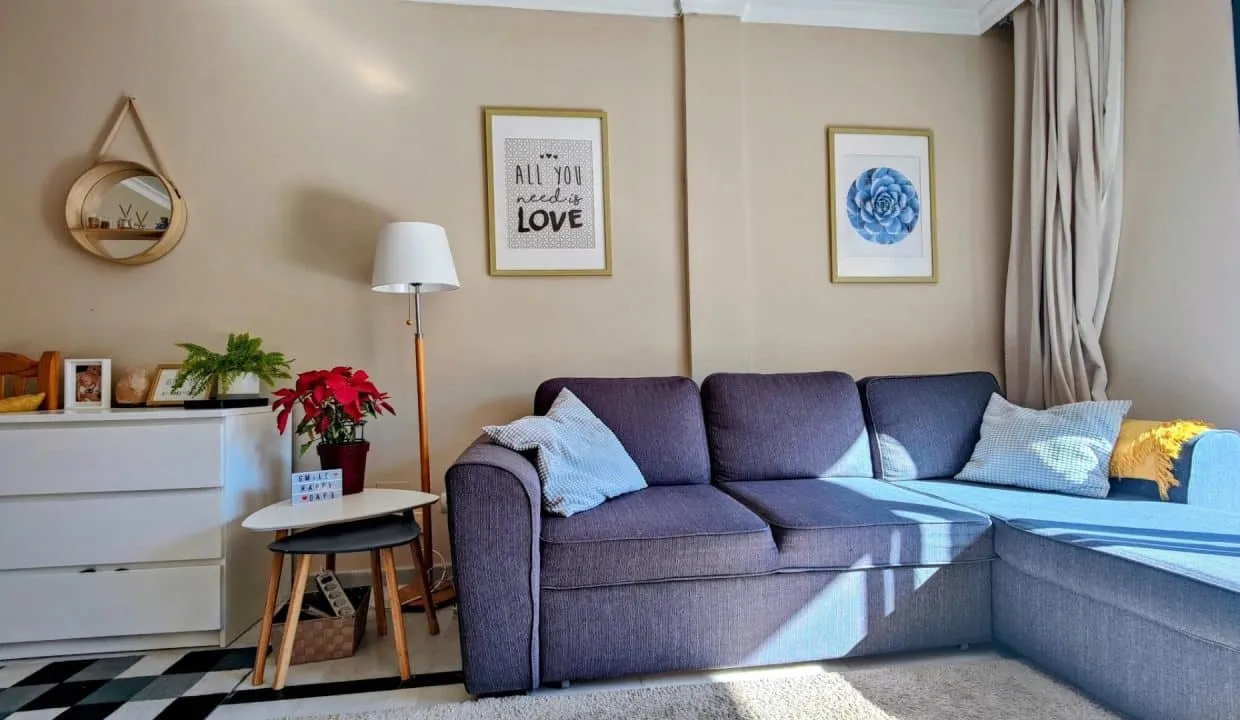 Salon avec canapé d'angle gris-bleu, commode blanche – appartement à louer, Las Terrazas de Bel Air, Estepona