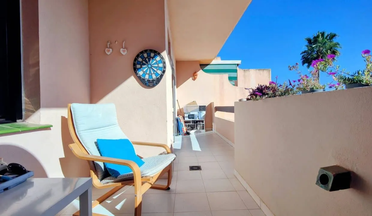 Terrasse avec fauteuil en bois et cible de fléchettes au mur – appartement à louer, Las Terrazas de Bel Air, Estepona
