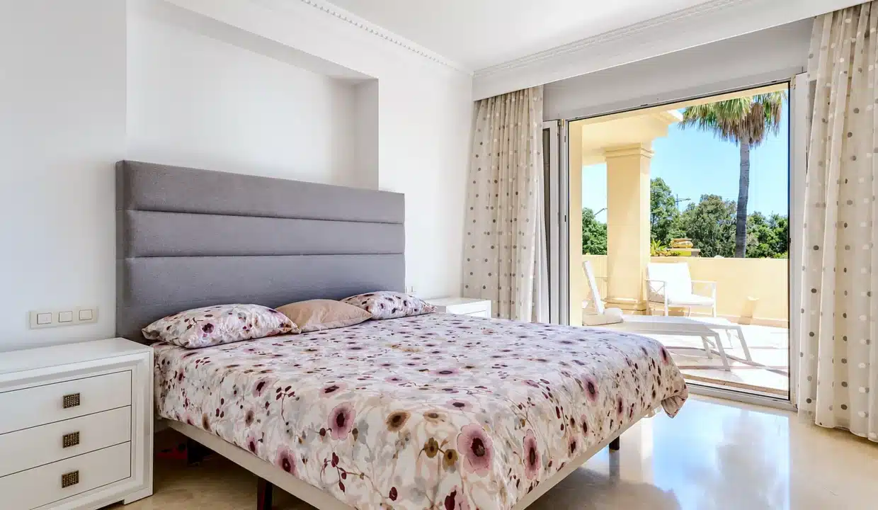 Dormitorio doble con cabecero gris, colcha floral – apartamento en alquiler, Majestic Hills, Casares (ref. AL014)