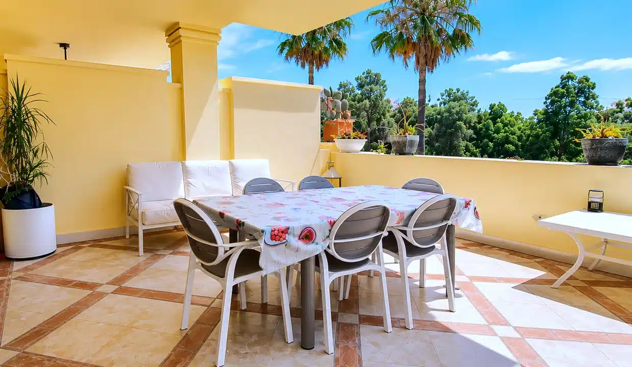 Terraza amarilla con mesa de comedor, sillas grises – apartamento en alquiler, Majestic Hills, Casares (ref. AL014)