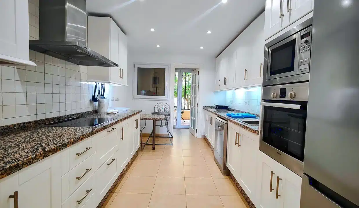 Cocina blanca alargada con encimeras de granito – apartamento en alquiler, Majestic Hills, Casares (ref. AL014)
