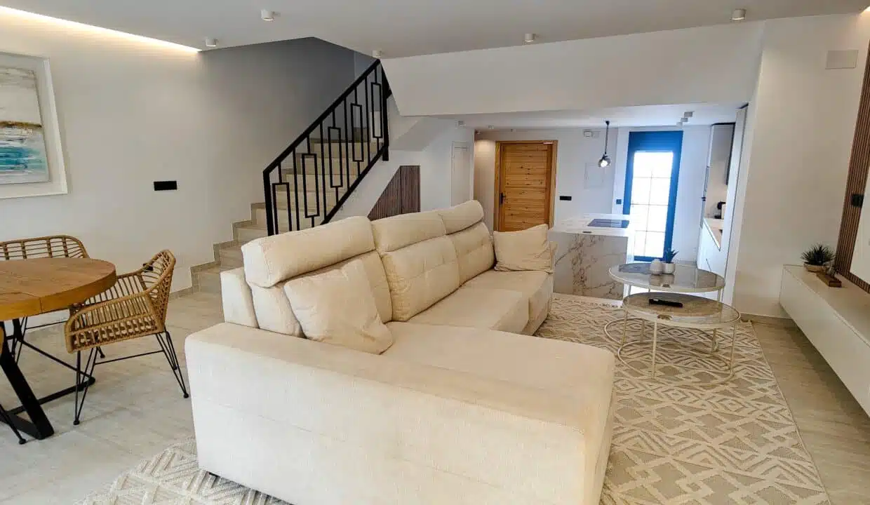 Séjour ouvert avec canapé d'angle crème, table ronde en bois – maison de ville à louer, Marina Casares, Casares (réf. AL053)