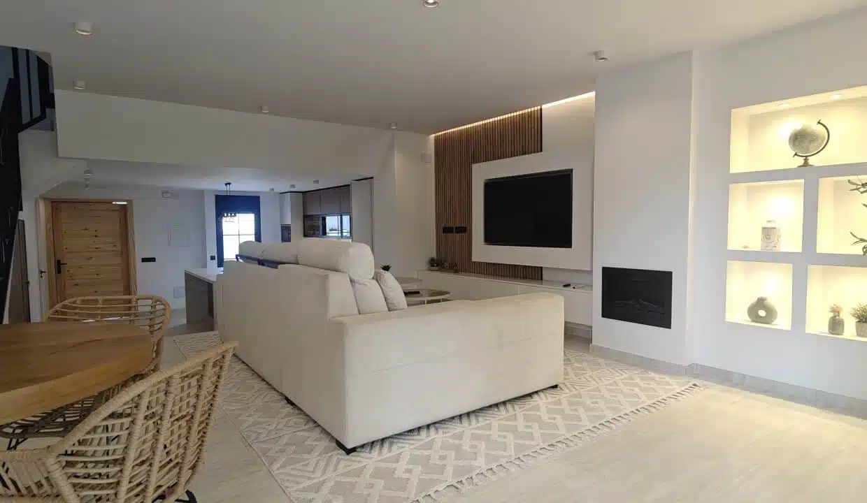 Salon au grand canapé crème, TV sur panneau en lattes de bois – maison de ville à louer, Marina Casares, Casares (réf. AL053)