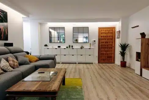 Living room with grey sectional sofa, yellow cushions and a large lion painting – apartment for rent, Estepona town centre