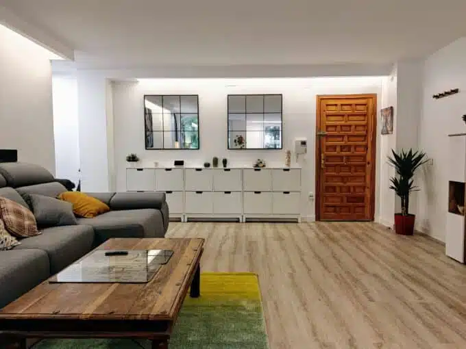 Living room with grey sectional sofa, yellow cushions and a large lion painting – apartment for rent, Estepona town centre