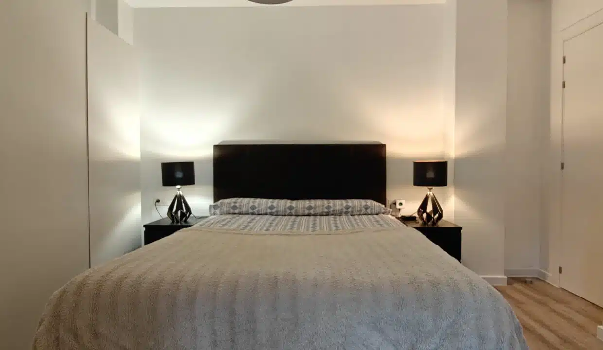 Double bedroom with black headboard and two bedside lamps – apartment for rent, Estepona town centre