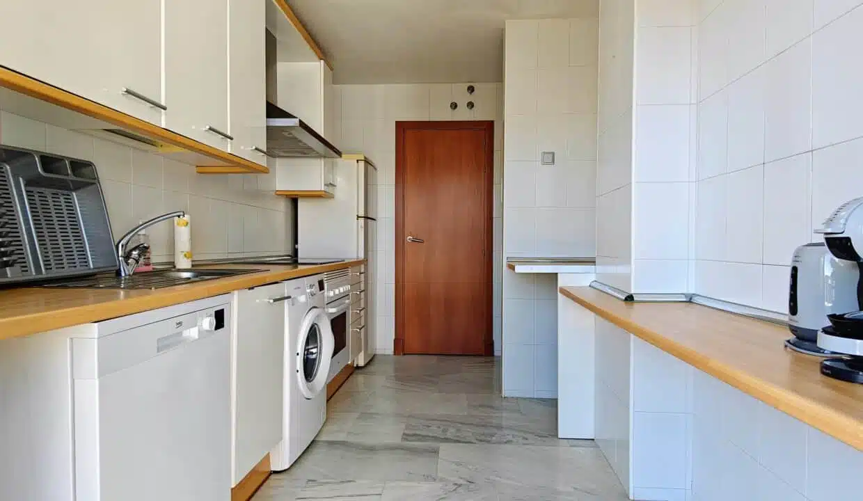 Cuisine en longueur avec meubles blancs, plan en bois – appartement à louer, Parque Botanico, Benahavís (réf. AL035)