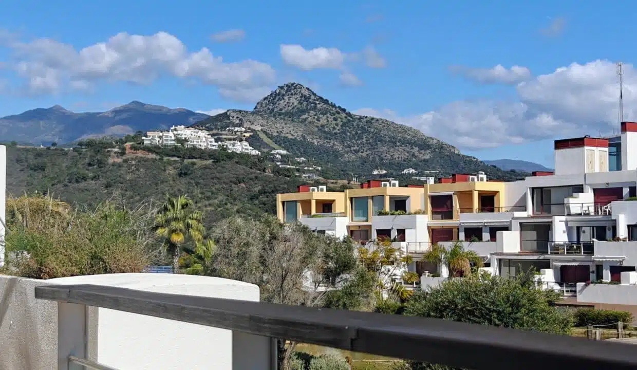 Vue depuis le balcon sur des immeubles colorés et une montagne – appartement à louer, Parque Botanico, Benahavís (réf. AL035)