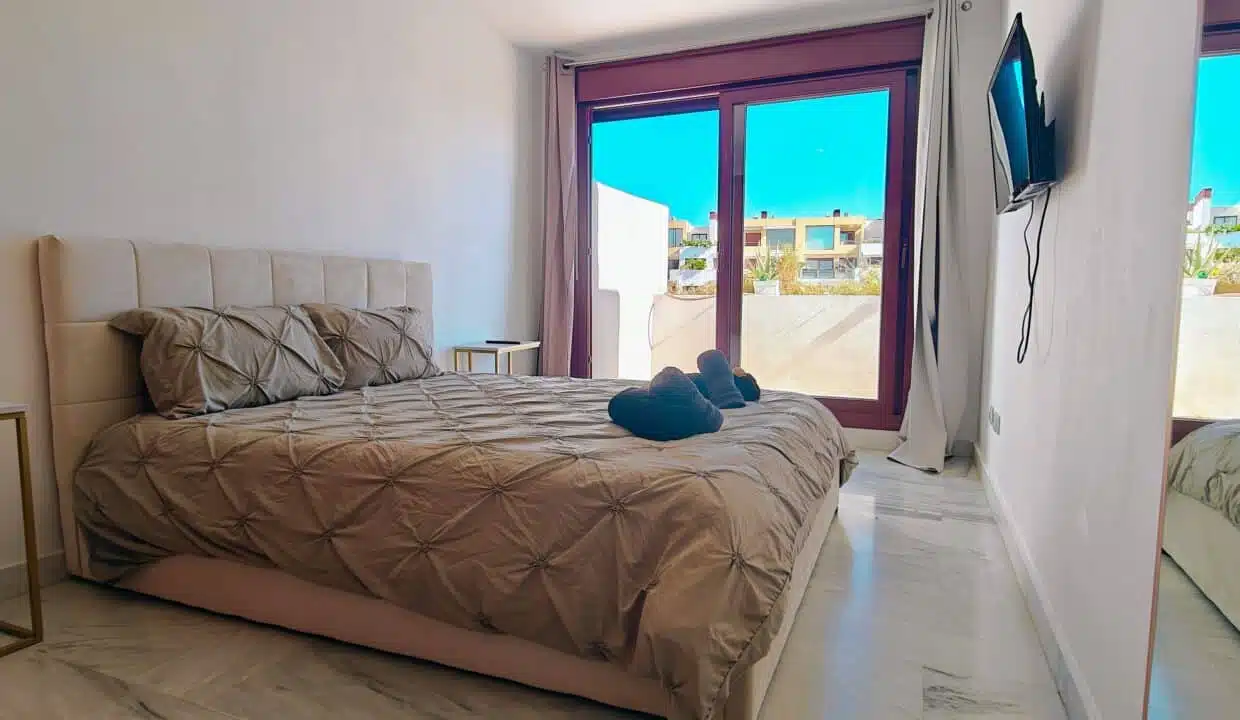 Chambre double à tête de lit beige, grande baie vitrée – appartement à louer, Parque Botanico, Benahavís (réf. AL035)