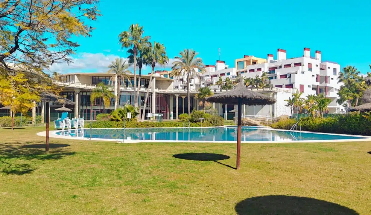 Piscine, pelouse et parasols de paille, immeubles blancs – appartement à louer, Parque Botanico, Benahavís (réf. AL035)