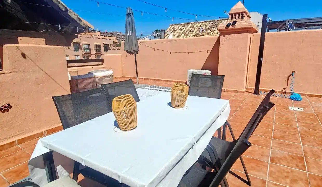 Terraza con mesa blanca, sillas negras, farolillos de mimbre – ático en alquiler, Casares del Sol, Casares (ref. AL013)