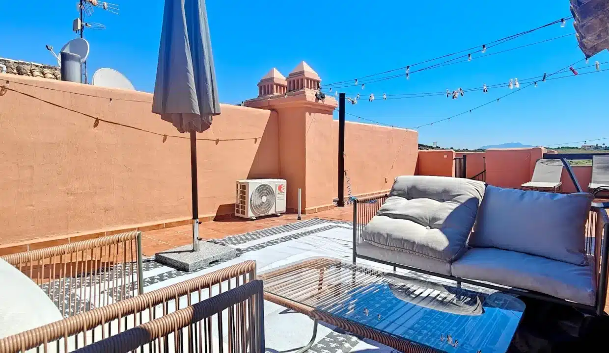 Terraza en la azotea de paredes naranjas con sofás de ratán – ático en alquiler, Casares del Sol, Casares (ref. AL013)