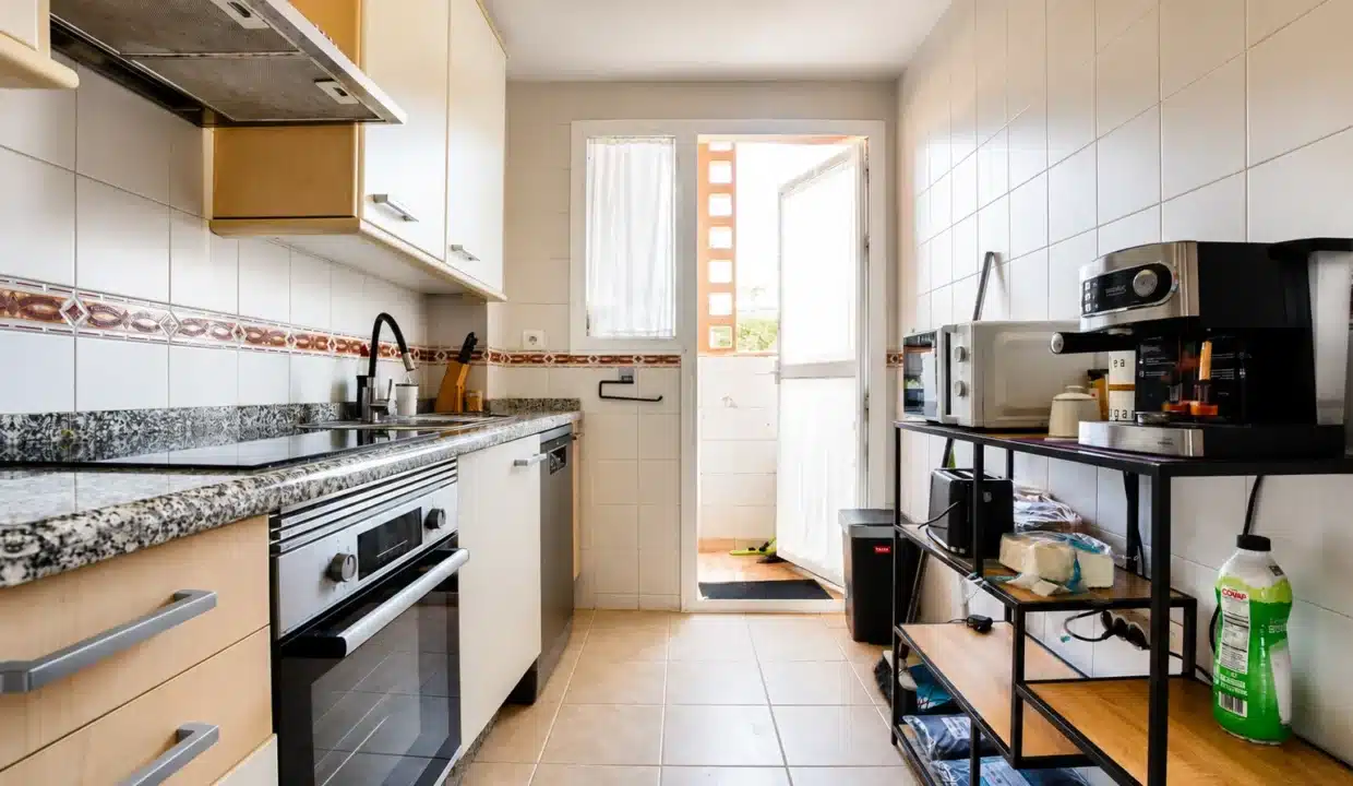 Cocina alargada con armarios de madera, encimera de granito – ático en alquiler, Casares del Sol, Casares (ref. AL013)