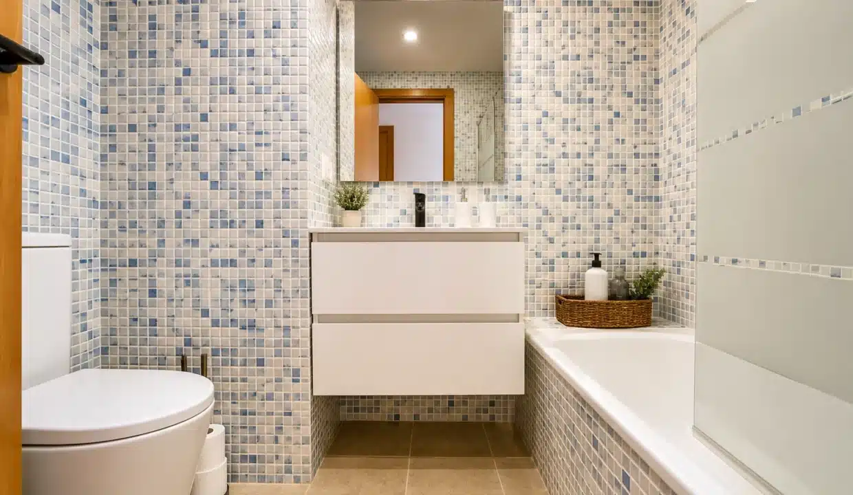 Baño con mosaico azul, mueble de lavabo suspendido blanco y bañera – ático en alquiler, Casares del Sol, Casares (ref. AL013)