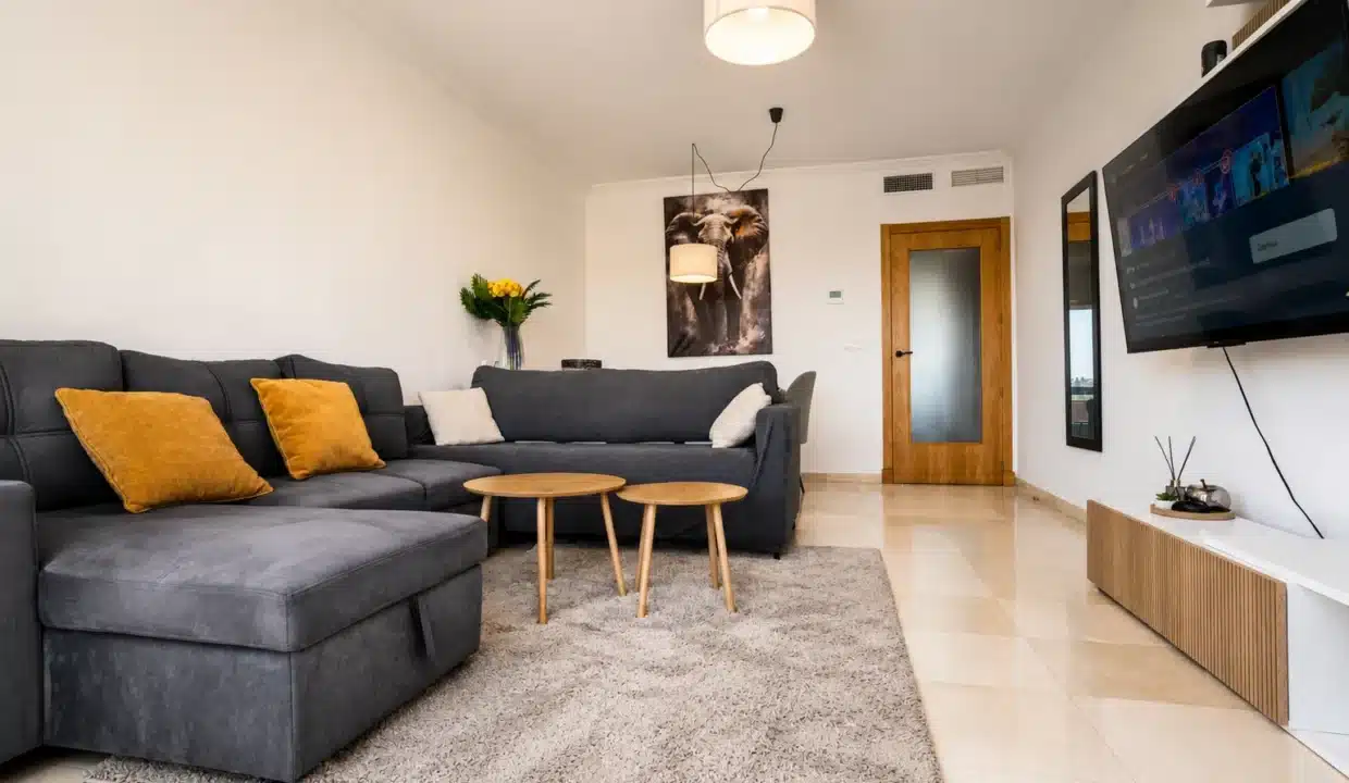 Salón con sofá gris, mesitas redondas de madera, alfombra – ático en alquiler, Casares del Sol, Casares (ref. AL013)