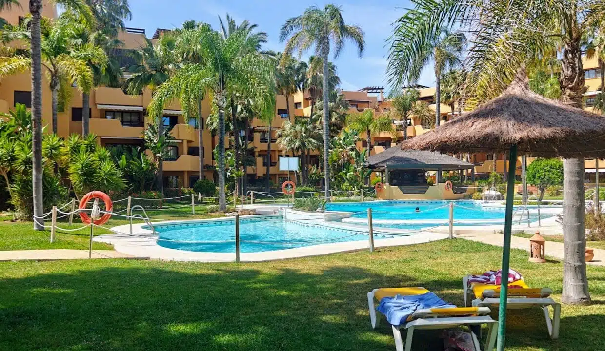 Pools among palm trees with a straw parasol – apartment for rent, Terrazas de Costalita, Estepona (ref. AL037)