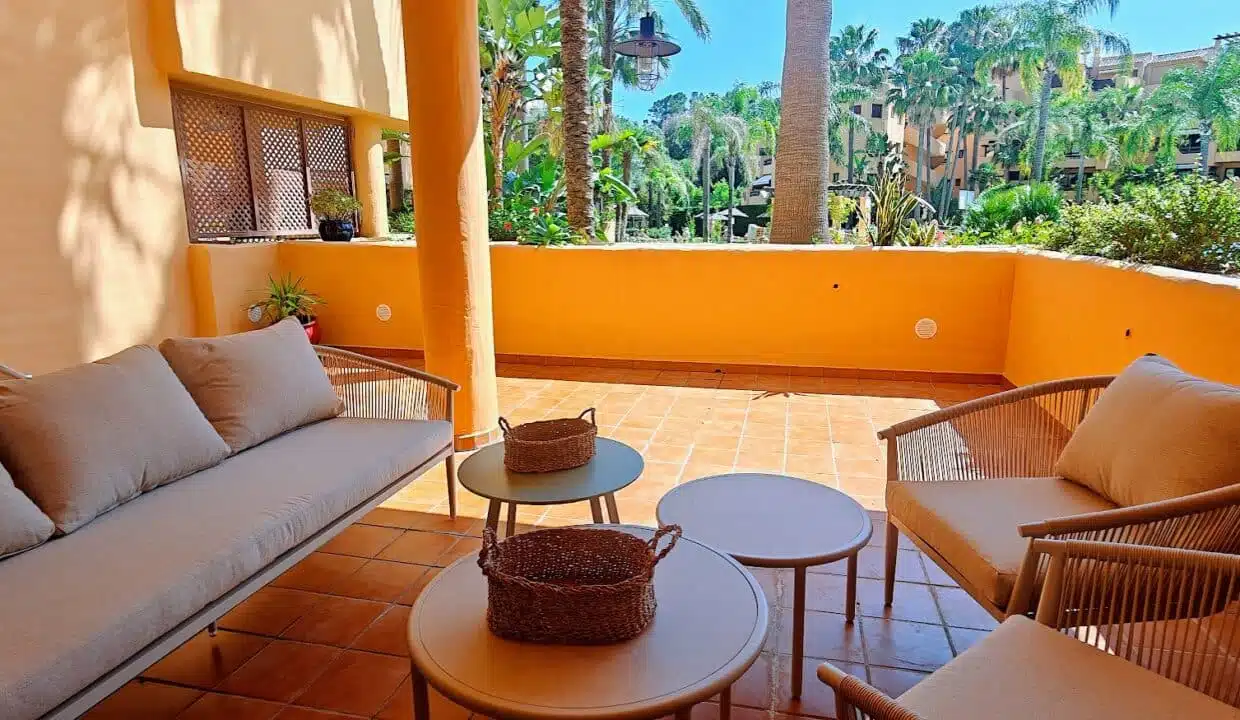 Orange-walled terrace with sofa, armchairs – apartment for rent, Terrazas de Costalita, Estepona (ref. AL037)