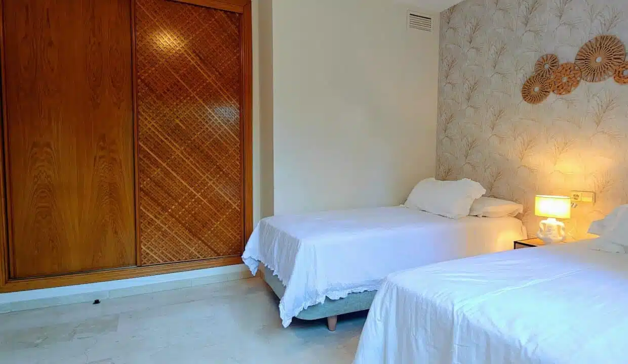 Twin bedroom with wooden wardrobe and palm-leaf wallpaper – apartment for rent, Terrazas de Costalita, Estepona (ref. AL037)