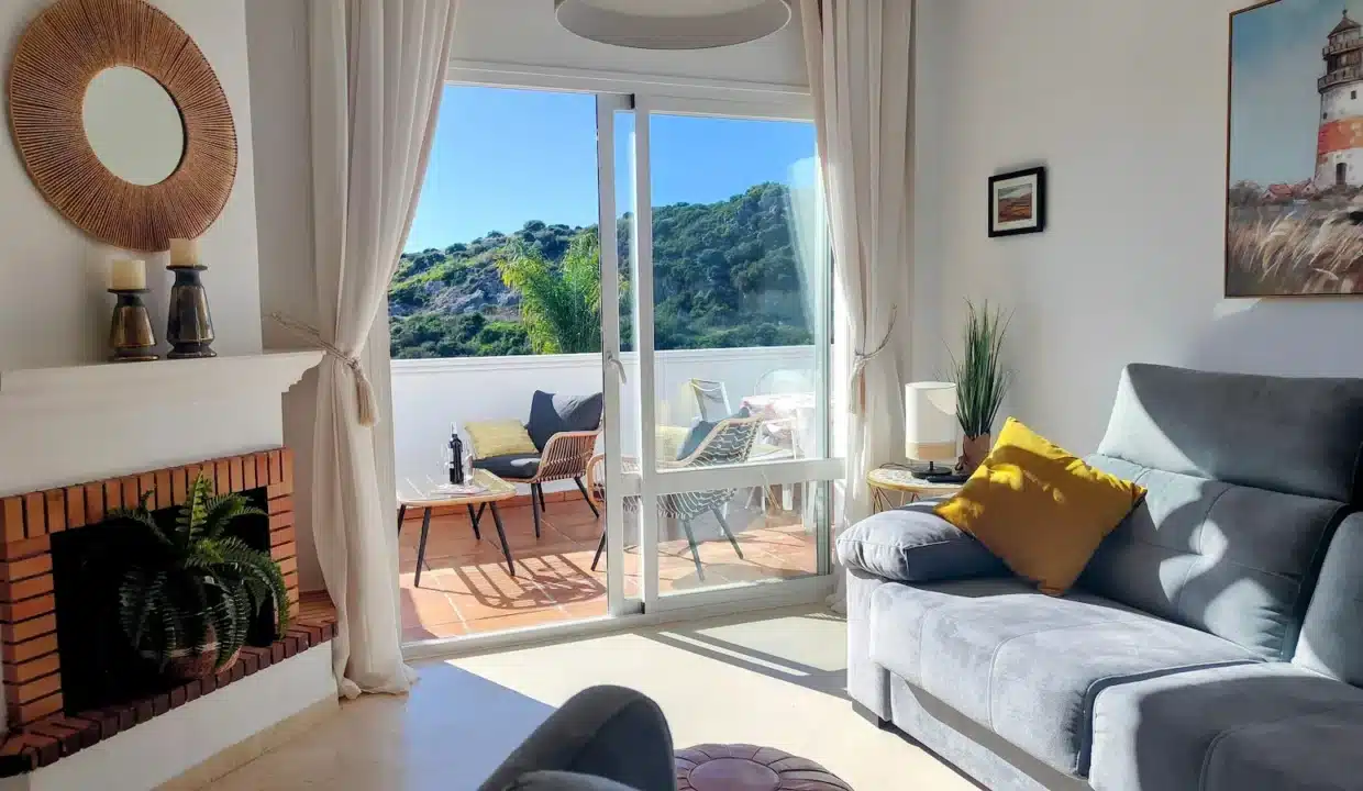 Salon avec cheminée en briques, canapé gris – appartement à louer, Casares Real, Casares (réf. SUM003)