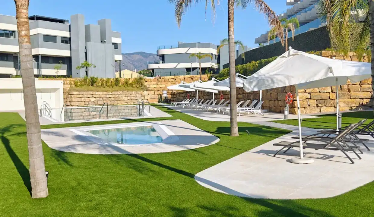 Jardin avec petite piscine, pelouse, parasols blancs et transats – appartement à louer, Oasis 325, Estepona (réf. AL038)