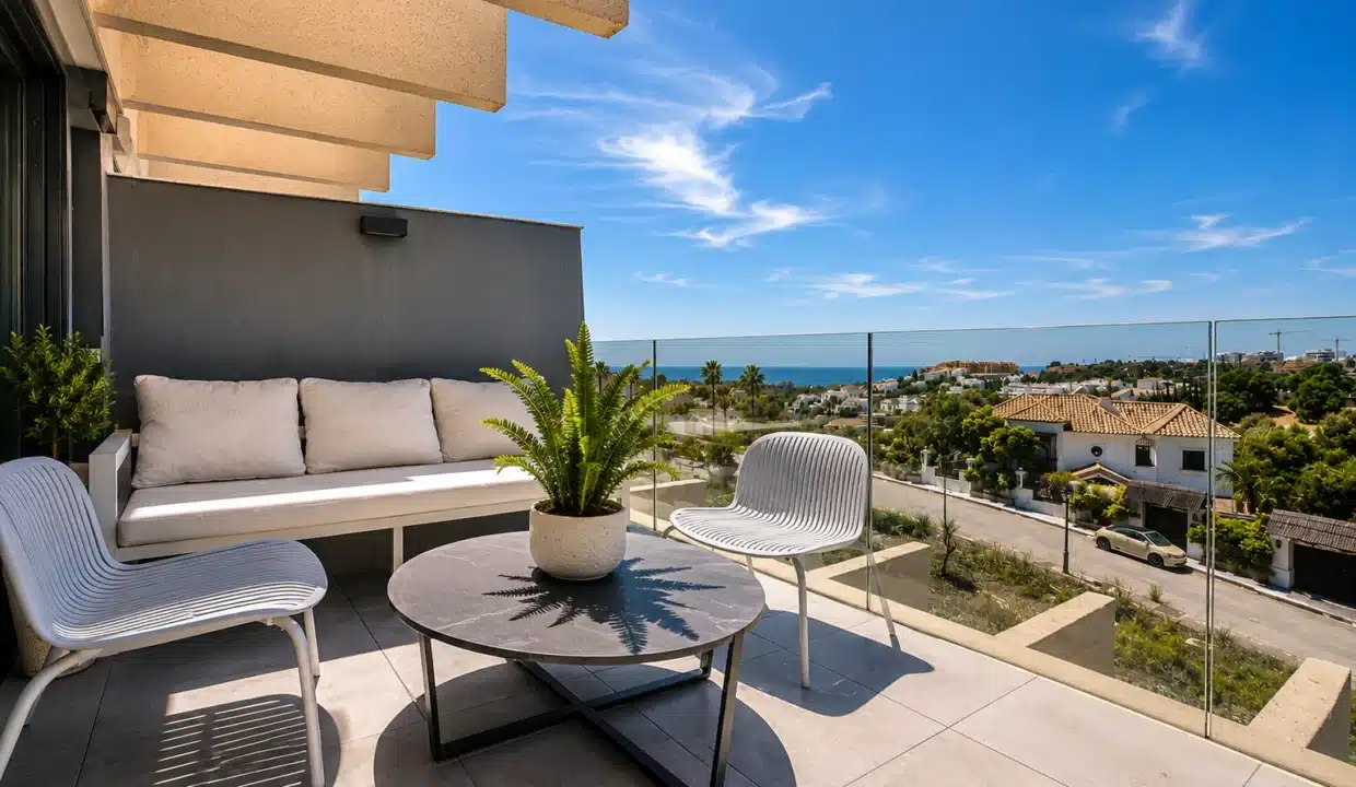 Terrasse avec canapé blanc, table ronde et vue sur la mer au loin – appartement à louer, Oasis 325, Estepona (réf. AL038)