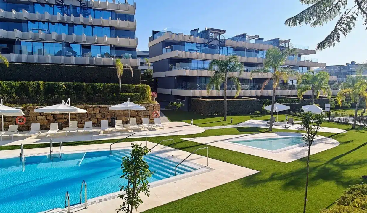 Piscine commune, pelouse et immeubles modernes aux balcons vitrés – appartement à louer, Oasis 325, Estepona (réf. AL038)