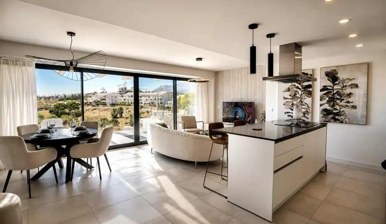 Séjour ouvert avec table ronde, canapé courbe crème et cuisine à îlot – appartement à louer, Oasis 325, Estepona (réf. AL038)
