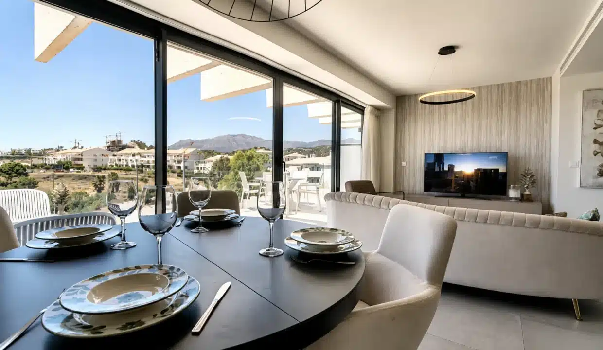 Table ronde noire dressée devant la baie vitrée, salon au fond – appartement à louer, Oasis 325, Estepona (réf. AL038)