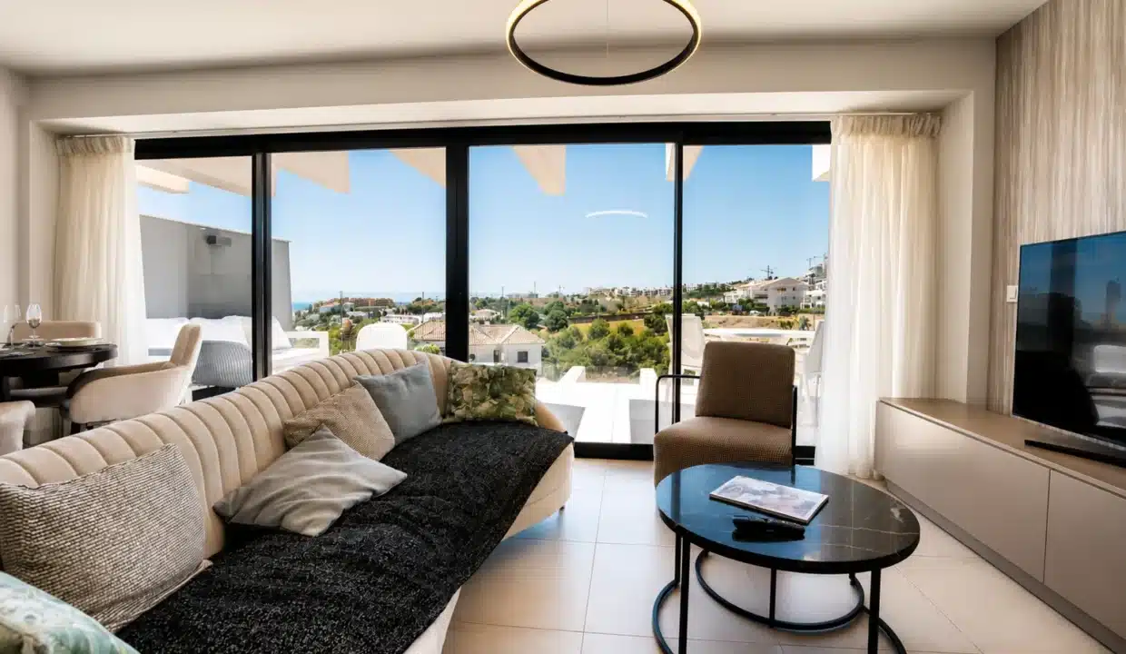 Salon avec canapé courbe crème, table basse ronde noire – appartement à louer, Oasis 325, Estepona (réf. AL038)