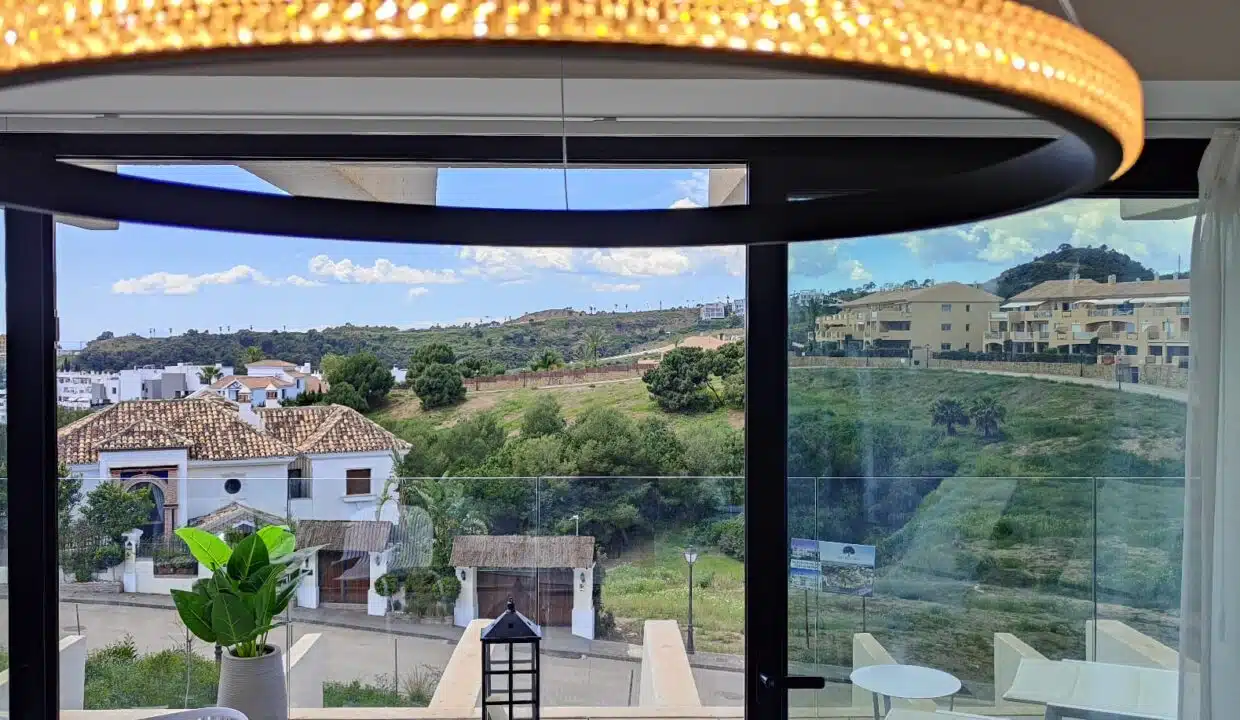 Vue depuis la baie vitrée sur des villas et des collines vertes – appartement à louer, Oasis 325, Estepona (réf. SUM038)