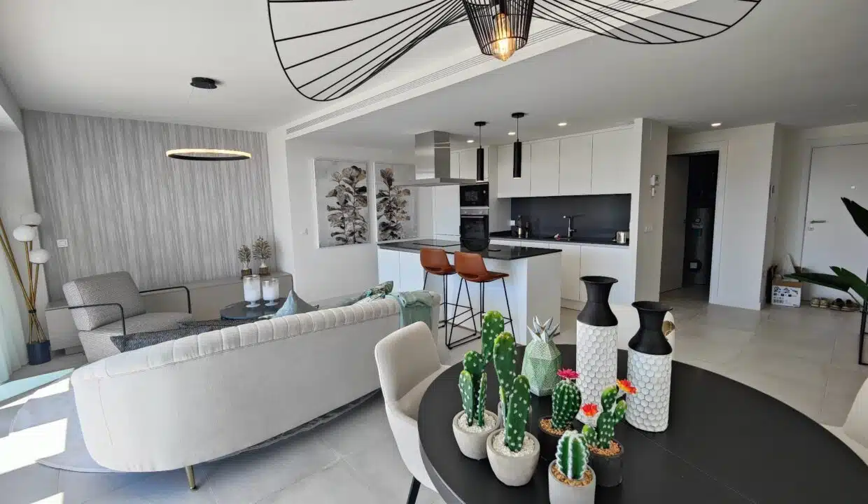 Séjour ouvert avec table ronde noire, cactus décoratifs – appartement à louer, Oasis 325, Estepona (réf. SUM038)
