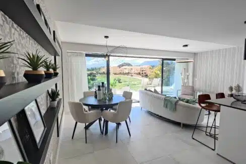 Dining area with cream chairs, plant shelves – apartment for rent, Oasis 325, Estepona (ref. SUM038)