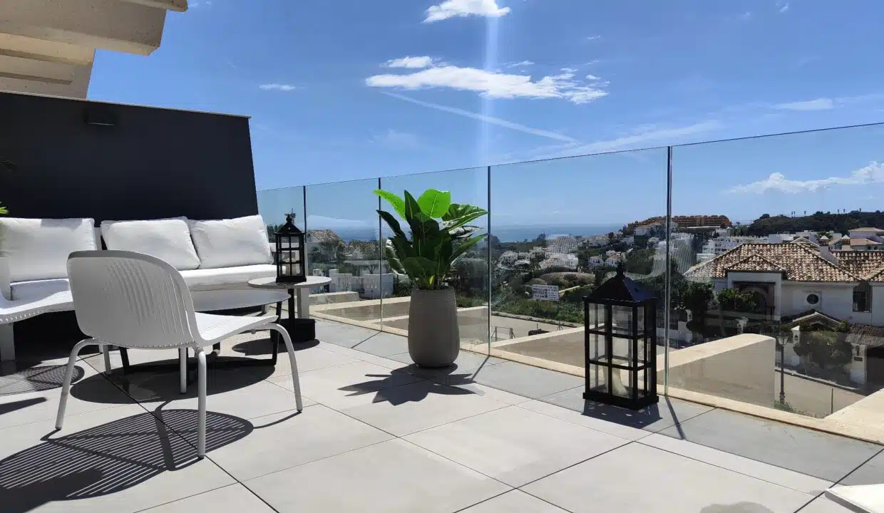 Terrasse avec canapé blanc, lanternes noires et vue sur la mer – appartement à louer, Oasis 325, Estepona (réf. SUM038)