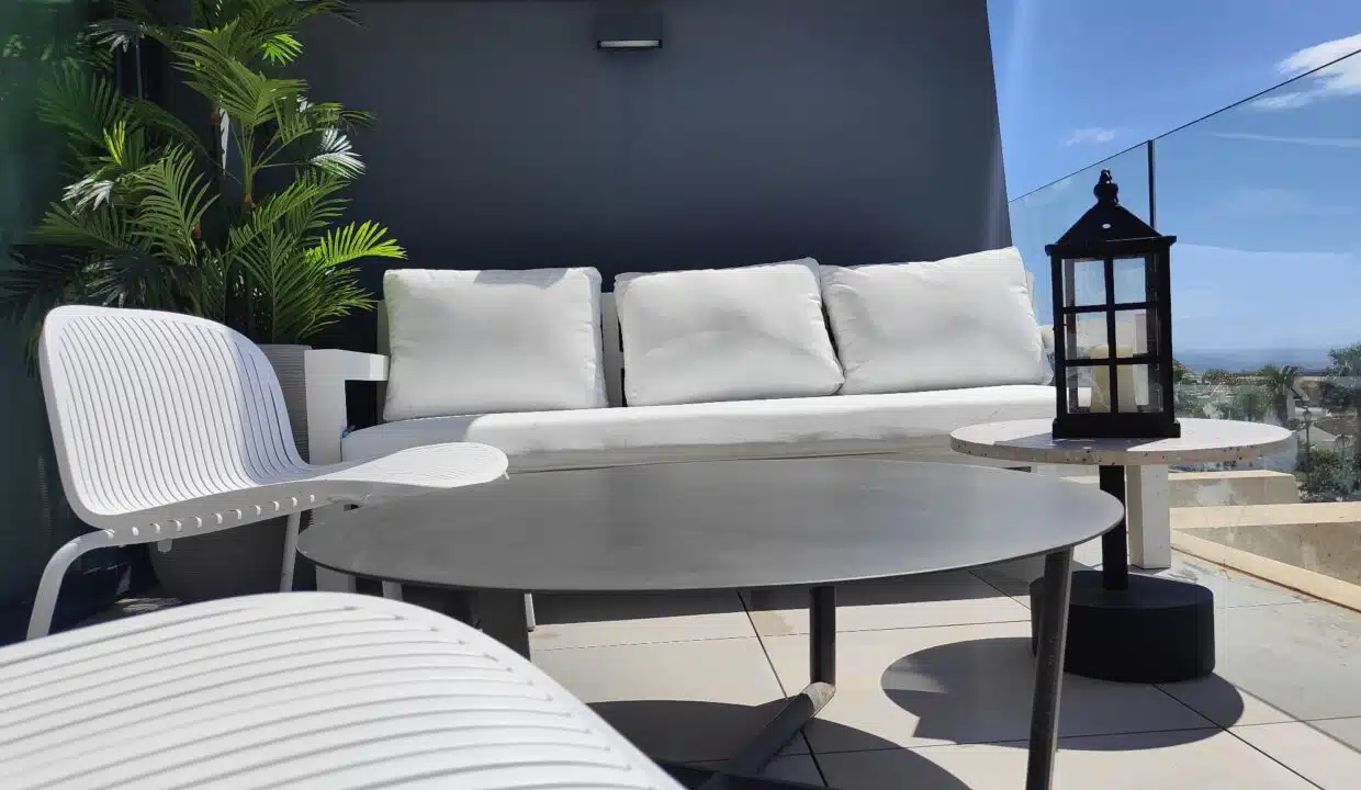 Salon de terrasse avec canapé blanc, table ronde grise et lanterne – appartement à louer, Oasis 325, Estepona (réf. SUM038)