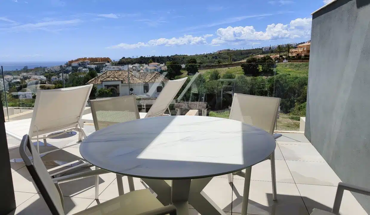 Terrasse avec table ronde, chaises, transats et vue dégagée – appartement à louer, Oasis 325, Estepona (réf. SUM038)