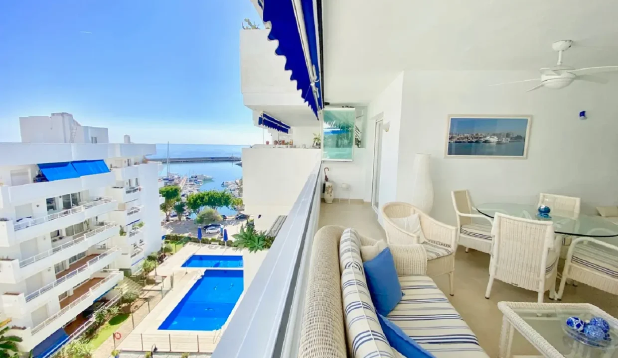 Terrasse avec salon en rotin blanc, vue sur la piscine et le port – appartement à louer, port d'Estepona (réf. AL051)