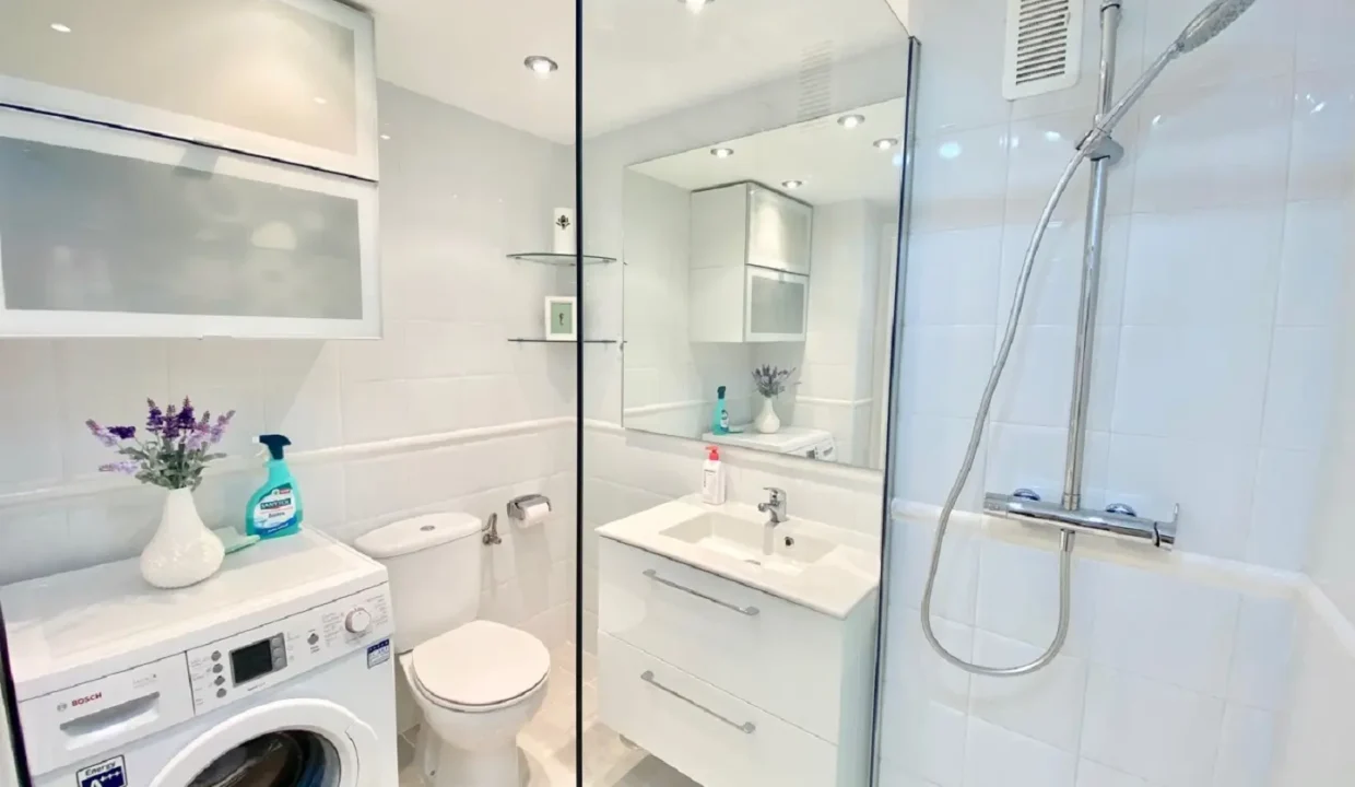 Salle de bain blanche avec douche, meuble vasque, WC et lave-linge – appartement à louer, port d'Estepona (réf. AL051)
