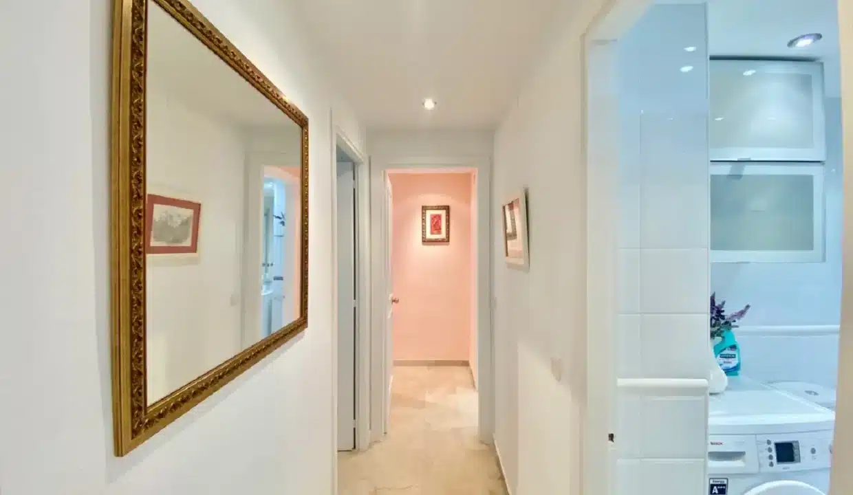 Couloir avec miroir au cadre doré et coin buanderie avec lave-linge – appartement à louer, port d'Estepona (réf. AL051)