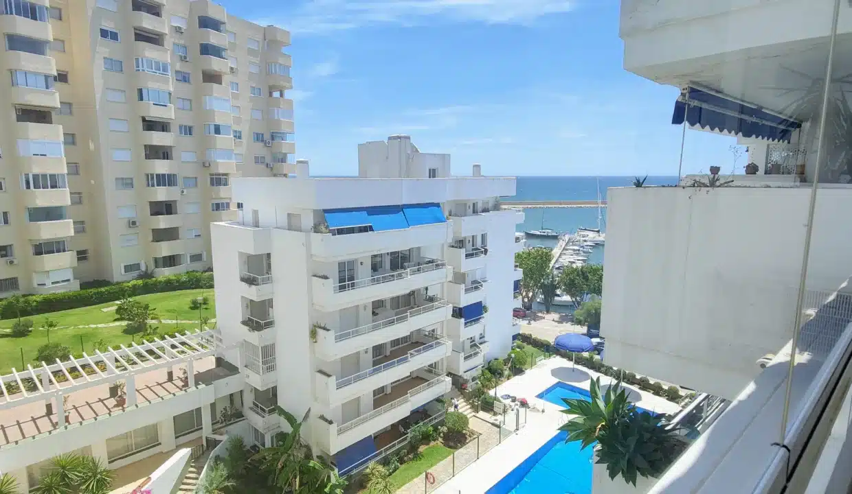 Vue du balcon sur la piscine, les immeubles, le port et la mer – appartement à louer, port d'Estepona (réf. AL051)
