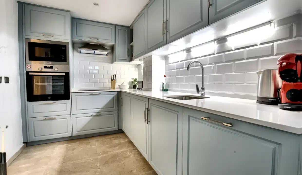 Cuisine en L aux meubles gris-bleu, crédence blanche en briques – appartement à louer, Casares Real, Casares (réf. AL003)