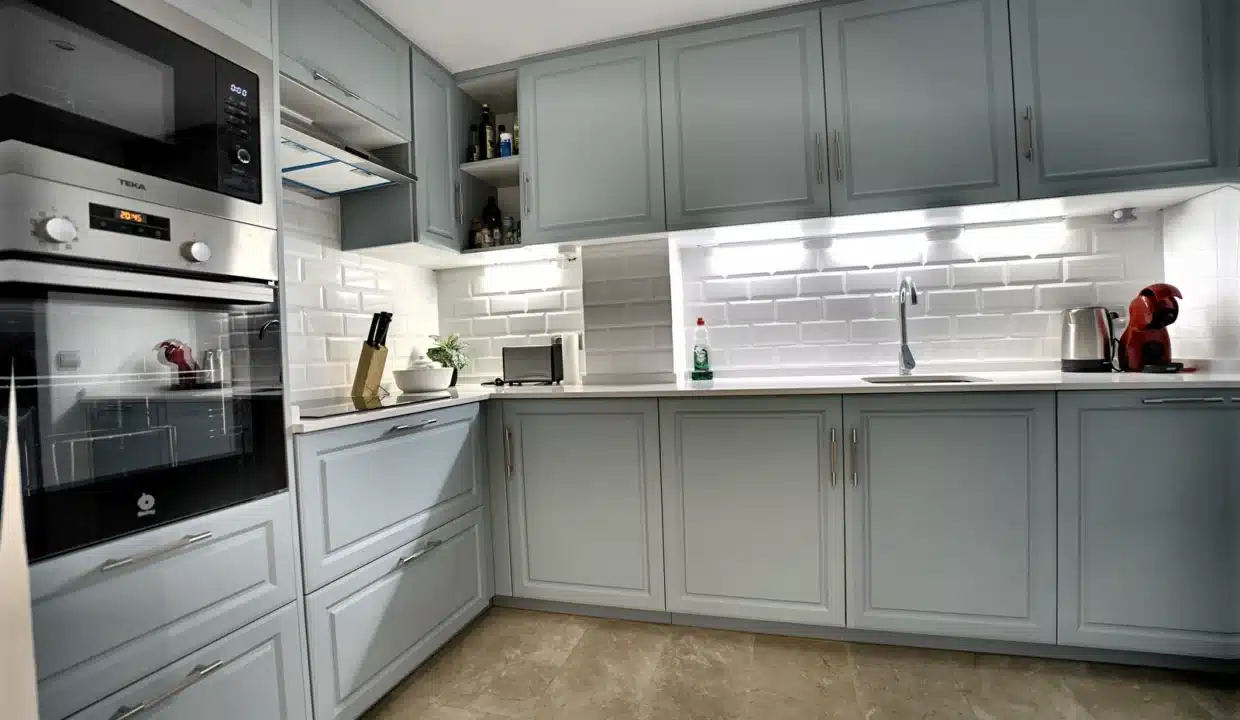 Cuisine avec placards gris-bleu, crédence en briques blanches, four – appartement à louer, Casares Real, Casares (réf. AL003)