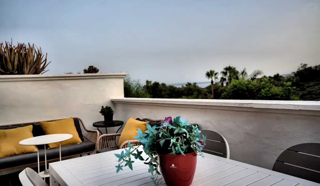 Terrasse avec canapé en rotin à coussins jaunes et table blanche – appartement à louer, Casares Real, Casares (réf. AL003)