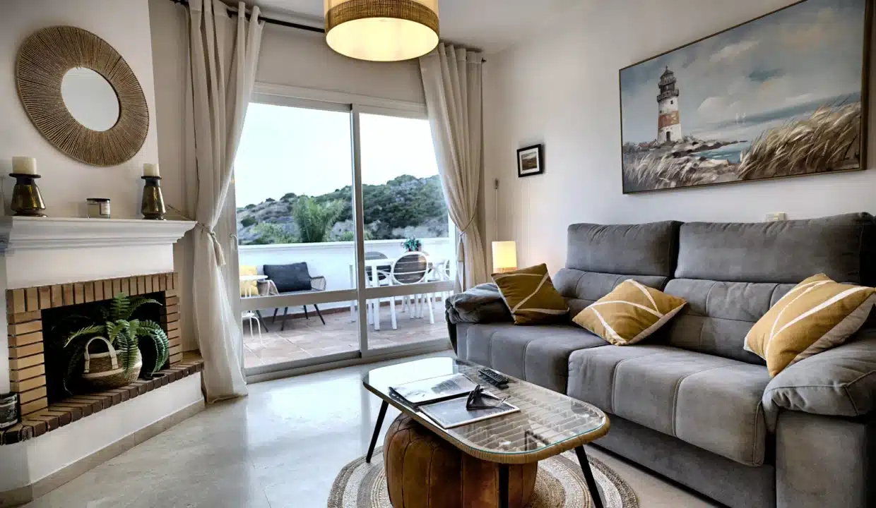 Salon avec canapé gris, cheminée, tableau de phare – appartement à louer, Casares Real, Casares (réf. AL003)