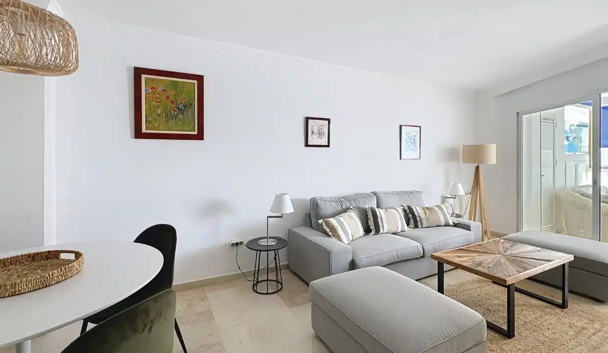 Salon au canapé gris, pouf et table basse en bois, table ronde blanche – appartement à louer, port d'Estepona (réf. AL051)