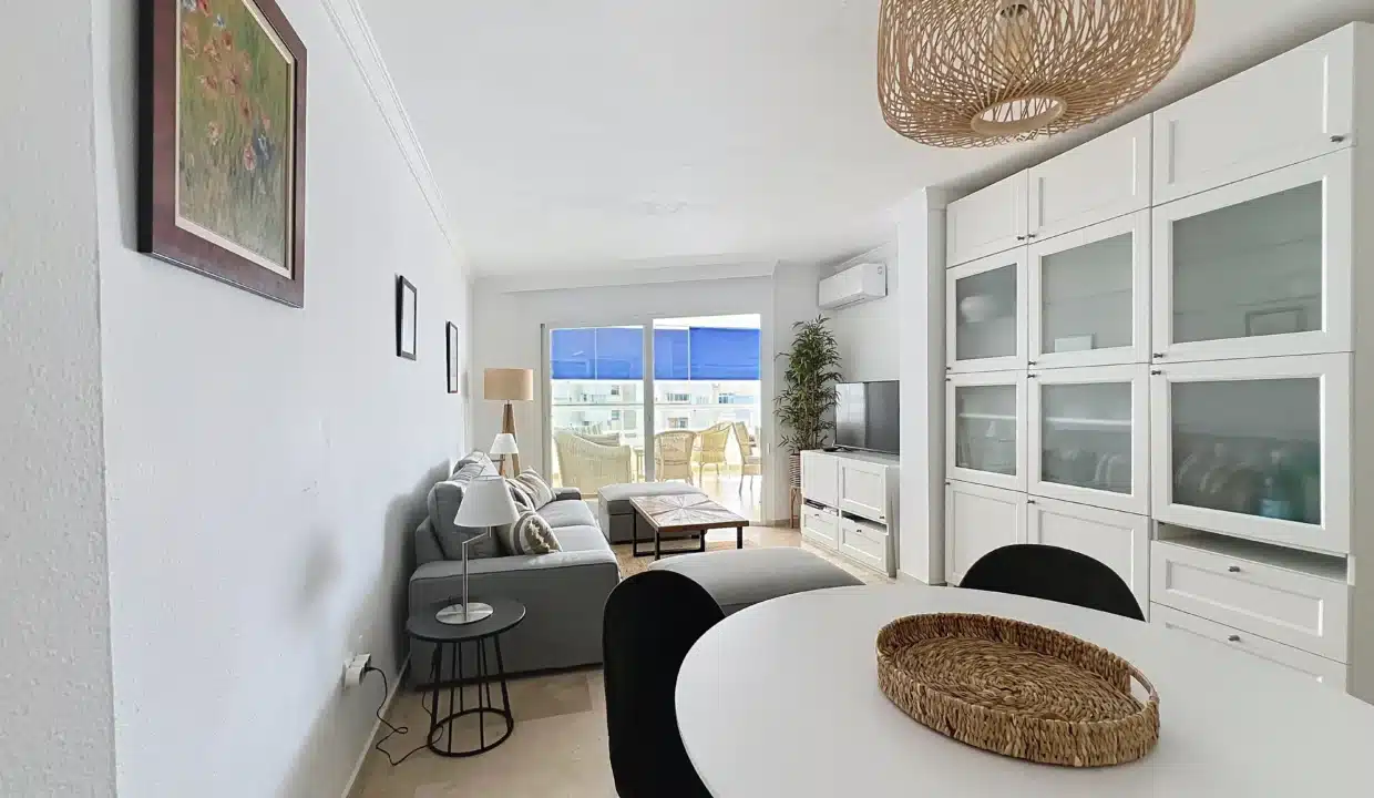 Séjour avec table blanche, chaises noires, canapé gris – appartement à louer, port d'Estepona (réf. AL051)