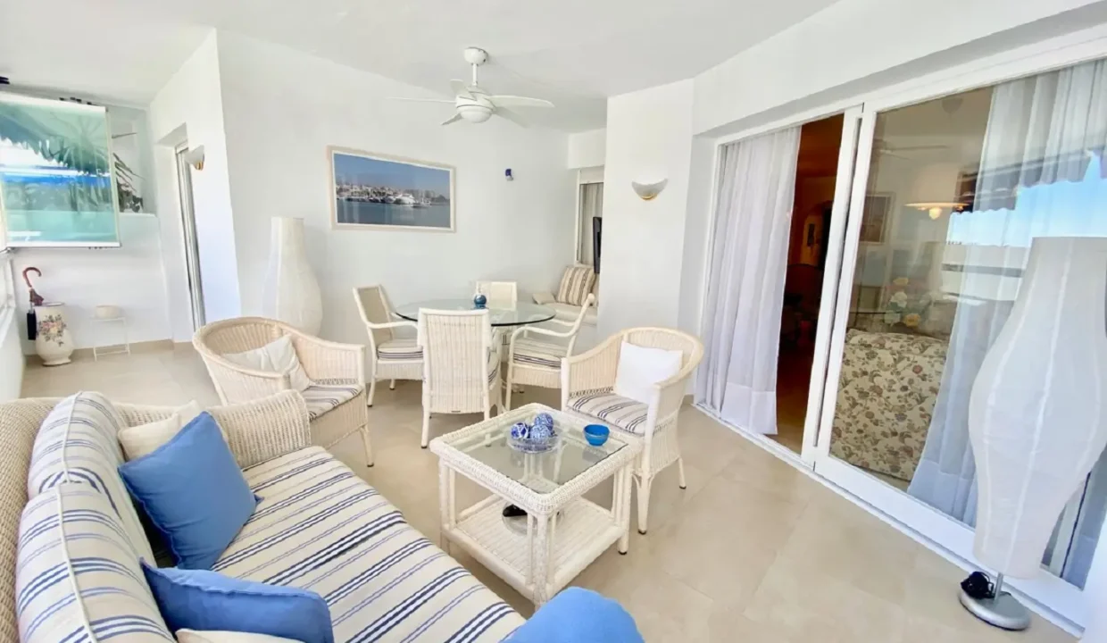 Terrasse couverte avec mobilier en rotin à coussins bleus rayés – appartement à louer, port d'Estepona (réf. AL051)