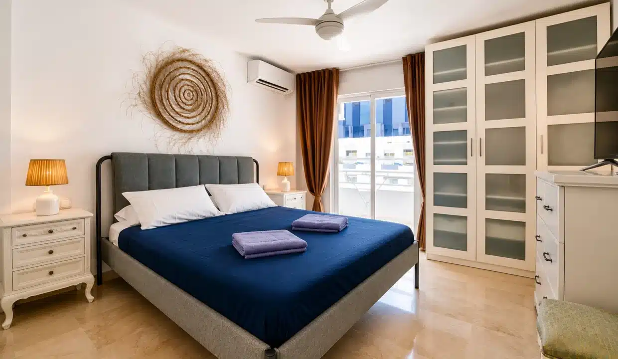 Chambre double au couvre-lit bleu marine – appartement à louer, port d'Estepona (réf. AL051)